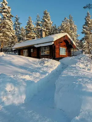 a log cabin with a pile of snow in front of it at Newly Built Log Cabin Near Hardangervidda in Geilo