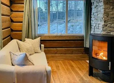 a living room with a fireplace and a couch at Newly Built Log Cabin Near Hardangervidda in Geilo