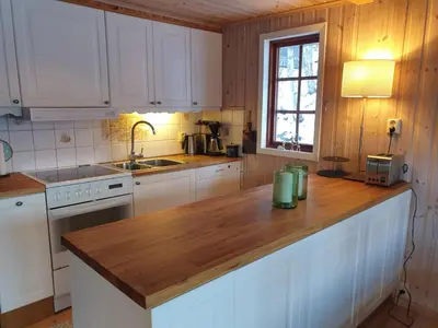 a kitchen with white cabinets and a wooden counter top at Filefjellhytta ved Tyin og Jotunheimen Ski in og ski out til alpinanlegg og skiløyper in Tyinkrysset