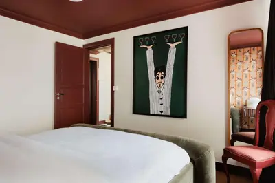 a bedroom with a white bed and a red chair at Bryggen Boutique l Stay Uniquely l 2 min to Floyen in Bergen