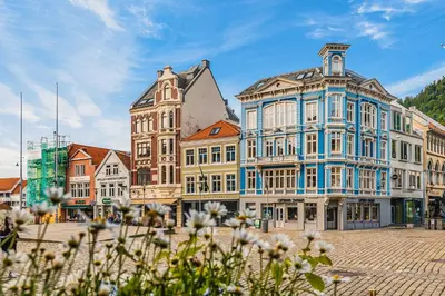 a group of buildings on a street with flowers at Bryggen Boutique l Stay Uniquely l 2 min to Floyen in Bergen