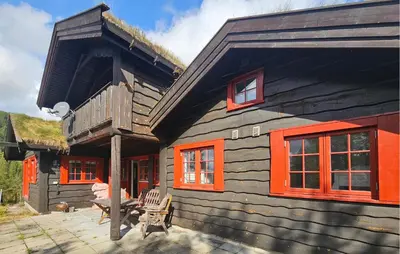 a log cabin with orange windows and a porch at Gorgeous Home In Eggedal With Sauna in Eggedal