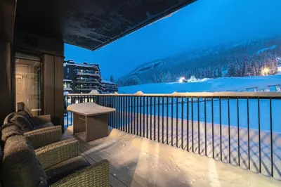 a balcony with a table and a view of the snow at Brand new luxury apartment by the slopes, Hemsedal in Hemsedal