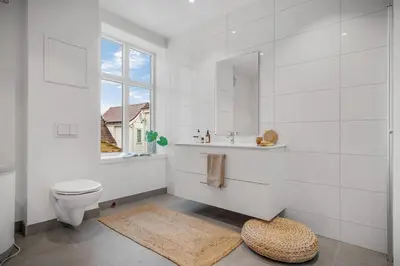 a bathroom with a toilet and a sink and a window at Beautiful 3 room apartment centrally located in Sandviken in Bergen