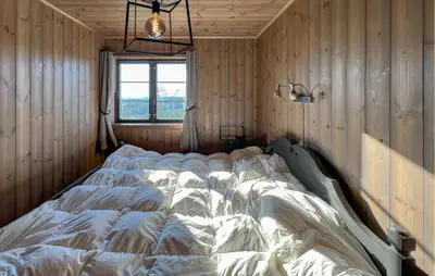 a large bed in a room with wooden walls at Stunning Home In Noresund With Sauna in Noresund