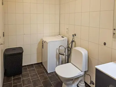 a bathroom with a toilet and a small refrigerator at Charming Farm Stay On Averøy Island in Averoy