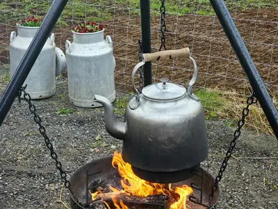 a tea kettle on top of a fire at Charming Farm Stay On Averøy Island in Averoy