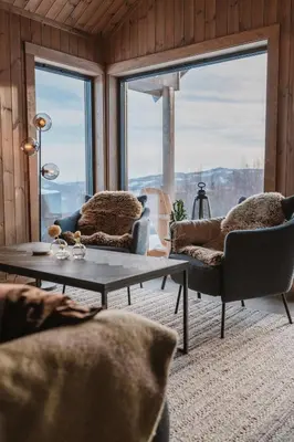 a living room with two chairs and a coffee table at Cozy Family Cabin Ski centre, shuttle bus in Noresund