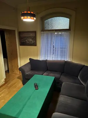 a living room with a couch and a green table at Fengselet Gjestegård in Leira