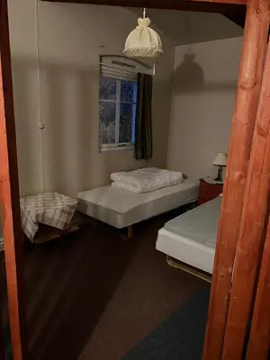 a room with two beds and a window at Fengselet Gjestegård in Leira