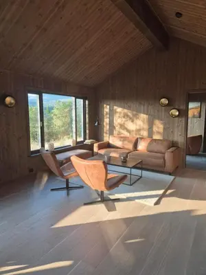 a living room with a couch and a table at Modern mountain cabin with panorama view in Eggedal