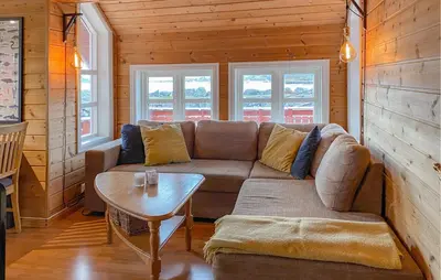 a living room with a couch and a table at 4 Bedroom Lovely Home In Leinøya in Fosnavåg