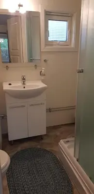 a bathroom with a sink and a toilet and a mirror at Et golfslag fra Stiklestad Golfklubb in Verdal