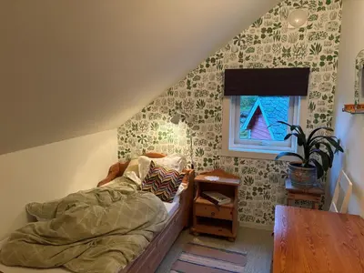 a bedroom with a bed and a table and a window at Jåstad Gjestetun in Jåstad