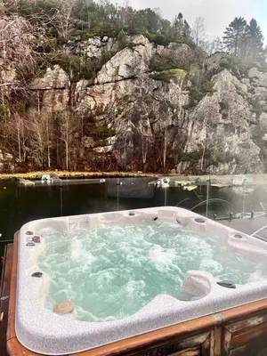 a jacuzzi tub in the middle of a body of water at Aurora Caravan Near Bergen in Strusshamn