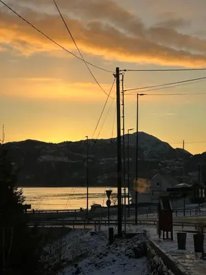 a sunset over a body of water with a mountain at Aurora Caravan Near Bergen in Strusshamn