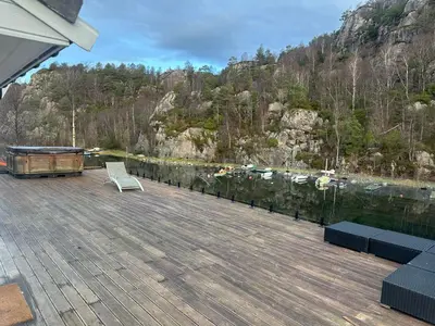 a deck with a chair and a table and a body of water at Aurora Caravan Near Bergen in Strusshamn