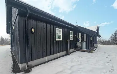 a black building with snow on the ground at Cozy Home In Ulnes With Sauna in Ulnes