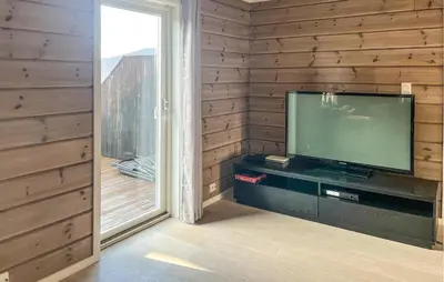 a flat screen tv sitting in a room with a window at 3 Bedroom Stunning Home In Hovden I Setesdal in Hovden