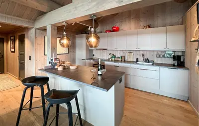 a kitchen with white cabinets and black stools at Amazing Home In Gålå With Sauna in Gålå