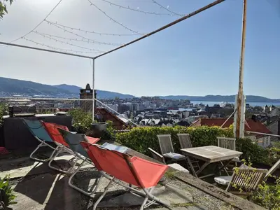 a group of chairs and a table on a roof at 2-roms leilighet med spektakulær utsikt og privat hage in Bergen