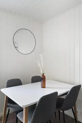 a white dining room with a white table and chairs at Centrum Apartment in Ålesund