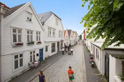 a group of people walking down a cobblestone street at Historic Apartment in the Heart of Bergen in Bergen