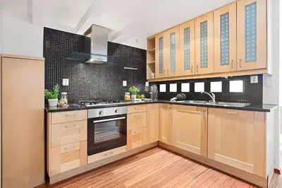 a kitchen with wooden cabinets and a stove top oven at Historic Apartment in the Heart of Bergen in Bergen