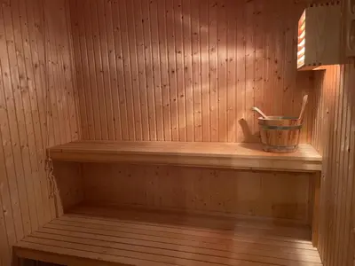 a sauna with a bucket on a wooden shelf at Koselig Og Sentral Hytte Med Peis Og Badstue in Beitostøl