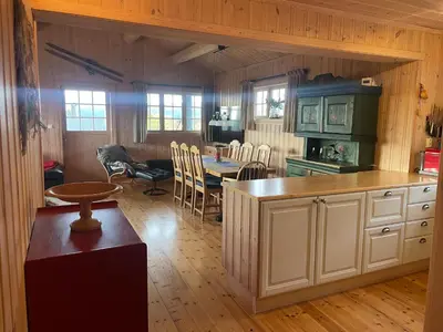 a kitchen with a table and a dining room at Koselig Og Sentral Hytte Med Peis Og Badstue in Beitostøl