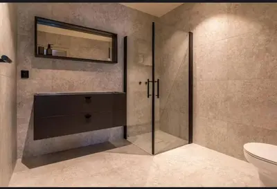 a bathroom with a shower with a mirror and a toilet at New house in the center of Trysil 2 in Trysil