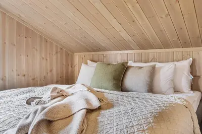 a bedroom with a bed with a wooden ceiling at Mountain Chalet 958 by Vacation Trysil in Trysil