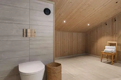 a bathroom with a toilet and a wooden wall at Mountain Chalet 958 by Vacation Trysil in Trysil
