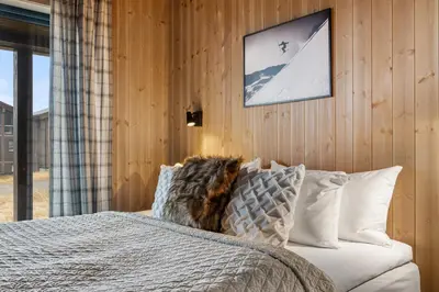 a bedroom with a bed with white pillows at Mountain Chalet 958 by Vacation Trysil in Trysil