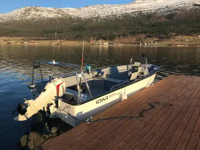 a small boat tied to a dock on the water at Solstrand Fjord Holiday in Eidsvåg