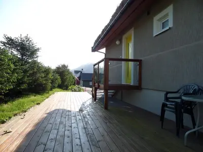 a porch of a house with a wooden deck at Solstrand Fjord Holiday in Eidsvåg