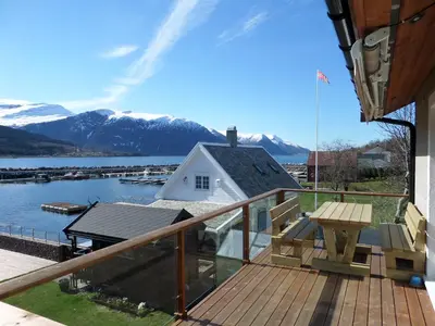 a balcony with a view of a lake and mountains at Solstrand Fjord Holiday in Eidsvåg