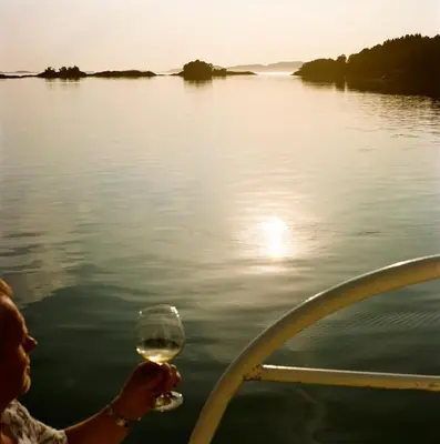a person is holding a glass of wine on a boat at Kyn Sjøstuer in Stavang