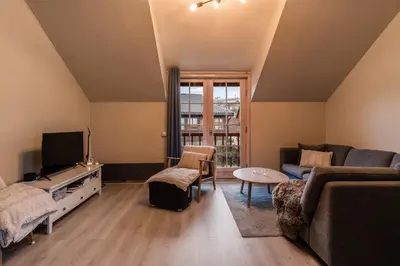 a living room with a couch and a tv at Alpine Apartment with Parking and Balcony in Ustaoset