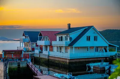 a row of houses on a dock at sunset at Vár Seaside Cabin in Stavang