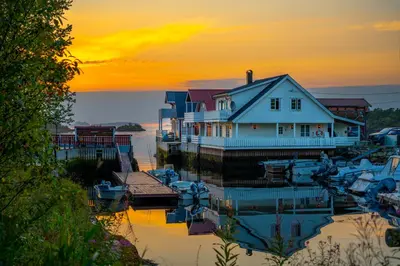 a house and boats in a marina at sunset at Eldur Seaside Cabin in Stavang