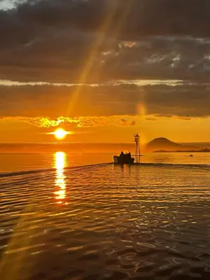 a boat on the beach at sunset with a rainbow at Eldur Seaside Cabin in Stavang