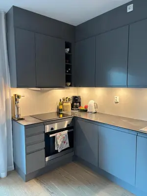 a kitchen with black cabinets and an oven at Stylish home near airport in Bergen
