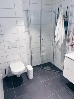 a white bathroom with a toilet and a shower at Stylish home near airport in Bergen