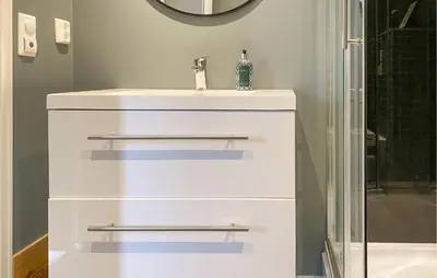a bathroom with a white sink and a shower at 2 Bedroom Cozy Home In Straumgjerde in Brunstad
