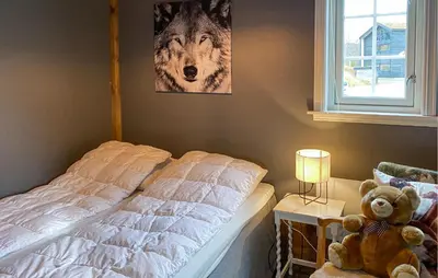 a bedroom with a bed with a teddy bear next to a window at 2 Bedroom Cozy Home In Straumgjerde in Brunstad