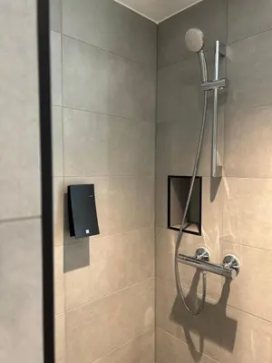 a shower with a shower head in a bathroom at Thon Hotel Verdal in Verdal
