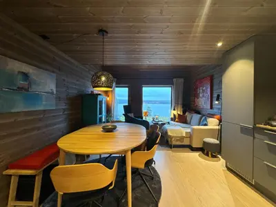 a dining room with a table and a living room at Moderne leilighet på Glomsrud Golsfjellet vest in Gol