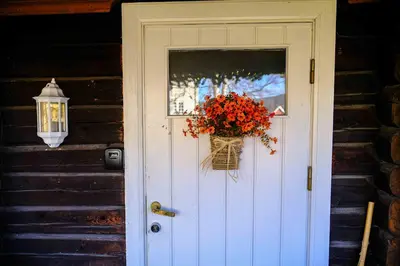 a white door with a basket of flowers on it at Leave It All in Venabygd