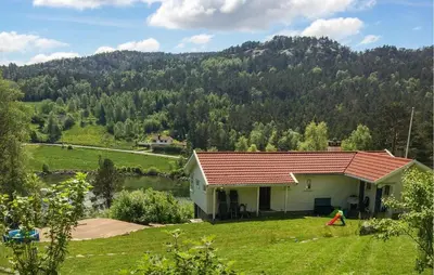 a house in a field with a mountain in the background at Cozy Home In Førde I Hordaland in Erve